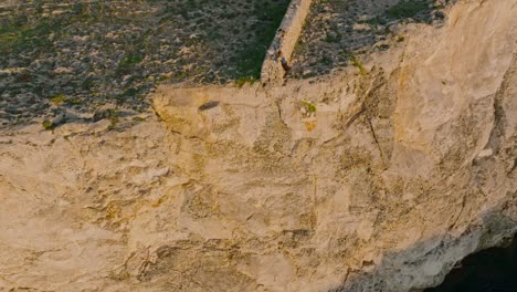 Rock-wall-on-edge-of-Sa-Falconera-Menorca-Spain-and-sheer-drop-off-cliff
