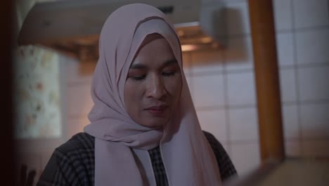 Nahaufnahme-Einer-Muslimischen-Asiatischen-Indonesierin-Im-Hijab,-Die-Sich-Sorgen-Macht,-Während-Sie-In-Der-Küche-Arbeitet