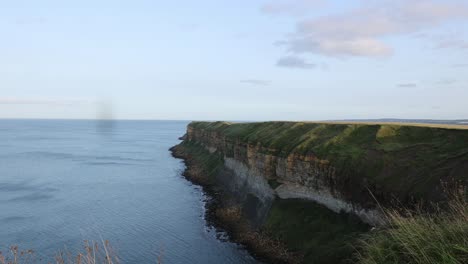 Static-shot-of-an-ocean-cliff-coastline-with-birds-flying-around