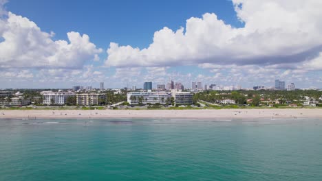 Gorgeous-pan-up-shot-of-Aerial-drone-view-of-west-palm-beach-coastline-skyline-downtown-area-and-beautiful-beach-sand-and-boats-in-water