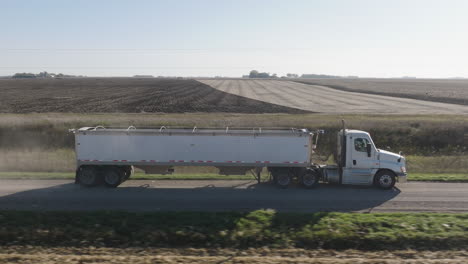 Aerial,-Semi-Truck-with-Hopper-Trailer-Driving-on-Rural-Countryside-Farm-Road-During-Daytime