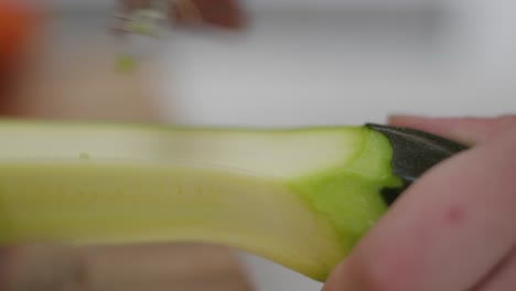 Person-hand-peeling-cucumber,-close-up-view