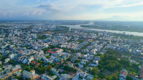 Luftaufnahme-Der-Flachen-Vietnamesischen-Stadtlandschaft,-Zersiedelung-Und-Fluss-Bei-Sonnenuntergang