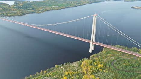 Vista-Superior-De-La-Impresionante-Infraestructura-Del-Puente-Hogakustenbron-Con-Bosques-Costeros-Otoñales-En-Suecia