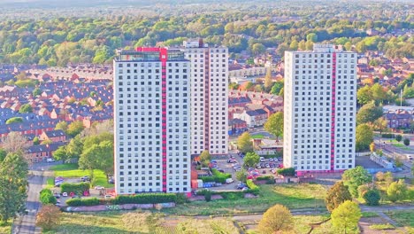Hohe-Weiße-Wohngebäude-Mit-Modernem-Roten-Streifen-Entlang-Des-Aufzugs-Bei-Sonnenaufgang-In-Manchester