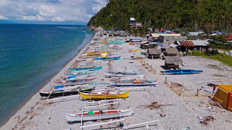 Aerial-of-fishing-boats-on-the-shores-of-Mabua-Pebble-Beach,-Surigao,-Philippines