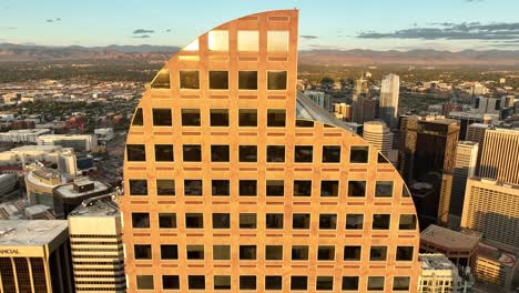 Aerial-descent-with-sunset-reflection-in-windows-of-Wells-Fargo-Center,-Denver