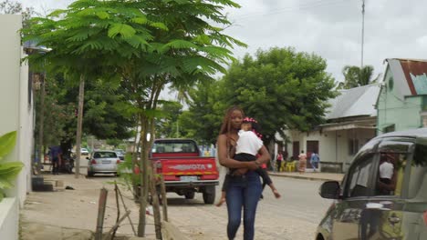An-unidentified-African-mother-with-her-daughter-in-her-arms-walking-down-an-African-street