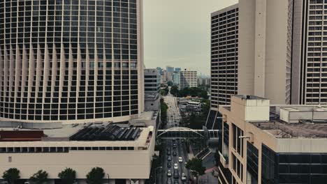 Aerial-tilt-up-shot-Hilton-Hotel-and-Marriot-Marquis-in-Downtown-of-Atlanta-with-traffic-on-main-Road-at-cloudy-day,-USA