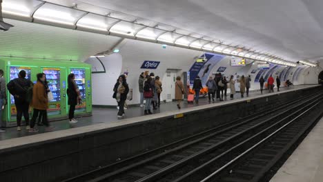 Pan-shot-of-locals-walking-on-platform-of-Opera-stop-of-Underground-subway-in-Paris,-France