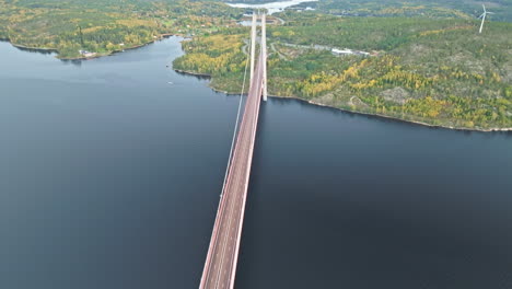 Overflying-Hogakustenbron-Metal-And-Concrete-Bridge-With-Autumn-Forest-Backdrop-In-Sweden