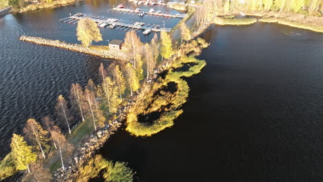 Rückwärtsflug-Auf-Dockbooten-über-Dem-Jachthafen-Mit-Herbstlichen-Naturbäumen-In-Schweden