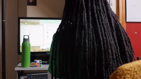 Man-with-long-dreadlocks-working-on-his-computer-at-home