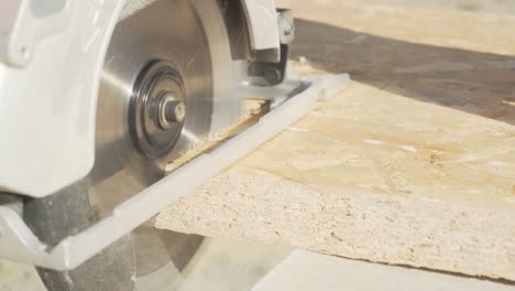 Handheld-close-up-shot-of-cutting-oriented-strand-board-with-circular-wood-saw