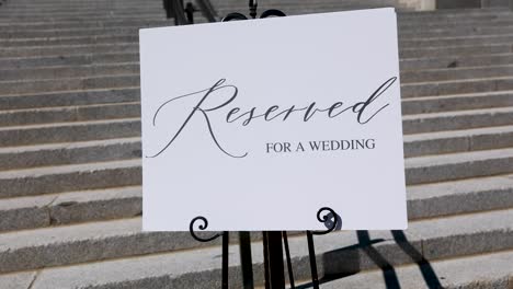 Reserved-sigh-on-white-poster-near-wedding-reception-building-with-stairs