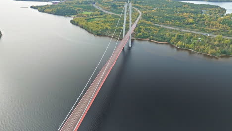 Flyback-über-Den-Panoramablick-Auf-Die-Hogakustenbron-Brücke-Mit-Herbstwald-Im-Hintergrund-In-Schweden