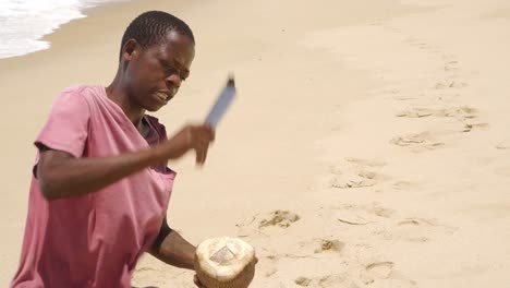 Unidentified-young-African-hustler-man-opening-a-coconut-to-sell-to-tourists-at-Praia-de-Tofo