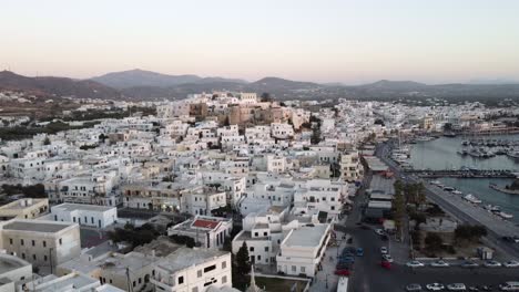 Aerial-view-of-Naxos-town-houses-and-coastline-on-a-beautiful-day,-Greek-Island-drone-footage