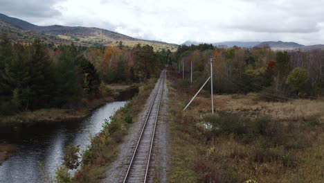 Aerial-Flying-Low-Along-Train-Tracks-Beside-Androscoggin-River