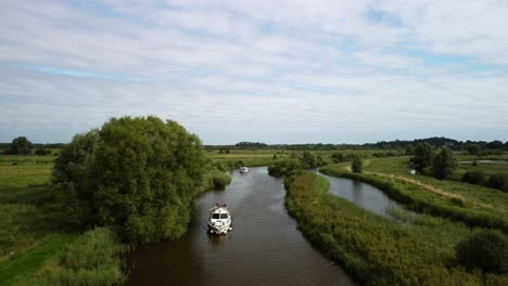 A-fly-away-Aerial-Drone-Footage-of-Boat-travelling-along-River-Yare-and-the-rural-surrounding-of-the-Norfolk-Broads