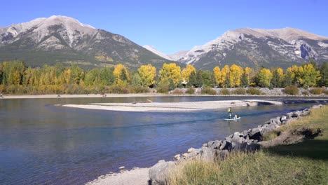 Paddle-boarder-with-dog-on-the-bow-river-in-Canmore,-AB