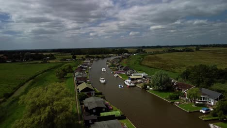 Luftdrohnenaufnahmen-In-4K,-Die-über-Ein-Boot-Fahren,-Das-Entlang-Des-Flussufers-In-Norfolk-Fährt