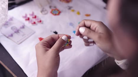 Closeup-of-woman´s-hands-making-crafts-with-colorful-little-beads,-needle-and-thread-003