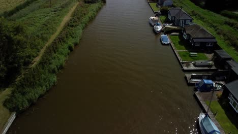 Aerial-Drone-4k-Footage-panning-up-along-the-River-Yare-with-some-boats-and-amazing-river-side-properties,-Norfolk-Boards,-Norfolk