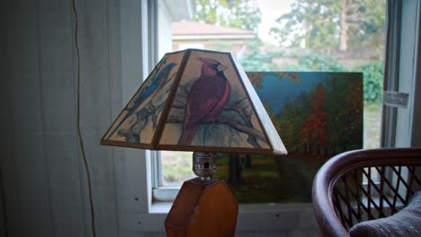 A-artwork-decorated-lamp-with-a-matching-piece-of-artwork-behind-it