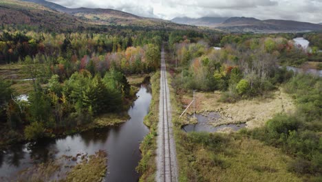 Drone-View-Of-Train-Tracks-and-Epic-Forest-Reveal-on-Overcast-Autumn-Day