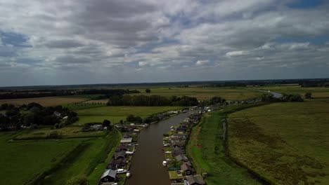 Aerial-Drone-4k-Footage-Dropping-Down-over-of-Boat-travelling-along-River-Yare,-Norfolk