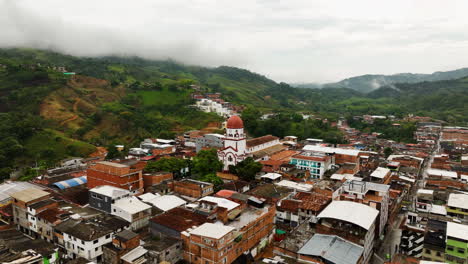Aerial-view-away-from-the-Saint-Raphael's-Church-in-cloudy-San-Rafael,-Colombia