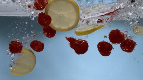 Raspberries-and-lemons-hitting-water-surface