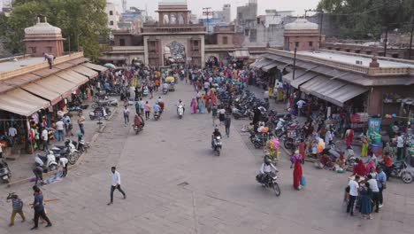 Gente-Caminando-En-La-Concurrida-Calle-Comercial-De-La-Ciudad-Por-La-Noche-Desde-Un-ángulo-Plano-El-Vídeo-Se-Toma-En-El-Mercado-De-Sardar-Ghantaghar-Jodhpur-Rajasthan-India-El-6-De-Noviembre-De-2023