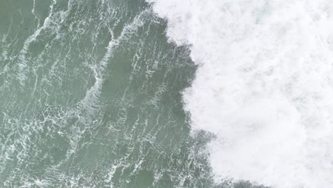 Slow-motion-wave-crashing-in-sea-Overhead-birds-eye-drone-aerial-view-4K