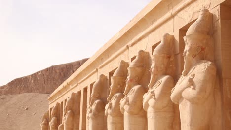 Eine-Reihe-Von-Pharaonenstatuen-Blicken-Auf-Das-Tal-Vor-Dem-Hatschepsut-Tempel-In-Luxor,-Ägypten