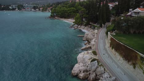 Drone-video-of-Mlini-bay-beach-with-the-rock-cliffs-to-stoney-beaches-then-the-surroundings,-Mlini,-Croatia