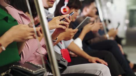 Young-people-using-mobile-phone-in-public-underground-train