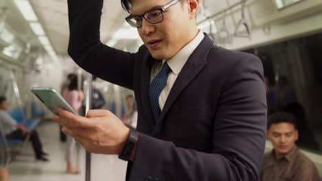 Businessman-using-mobile-phone-on-public-train