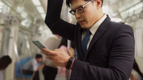 Businessman-using-mobile-phone-on-public-train