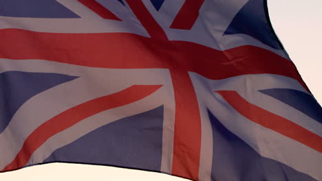 Bandera-Del-Reino-Unido-Ondeando-Sobre-El-Cielo-Del-Atardecer.
