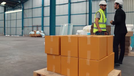 Factory-workers-deliver-boxes-package-on-a-pushing-trolley-in-the-warehouse-.