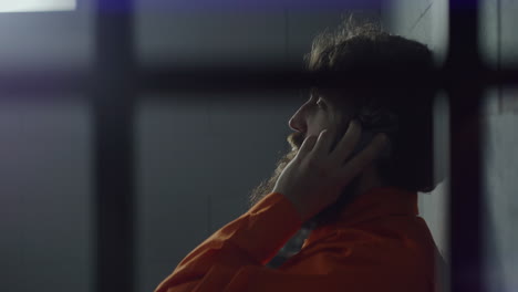 Criminal-in-Orange-Uniform-Talks-on-Phone-in-Prison-Cell