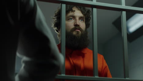 Gefangener-In-Orangefarbener-Uniform-Telefoniert-In-Gefängniszelle