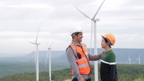 Progressive-engineer-with-his-son-in-the-wind-farm-atop-of-the-mountain.