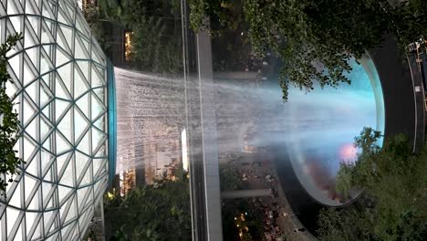 Erstaunlicher-Indoor-Wasserfall,-Der-In-Zeitlupe-In-Das-Beleuchtete-Blaue-Loch-Am-Flughafen-Jewel-Changi-Stürzt