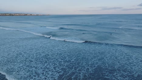 Aerial-Drone-shot-of-York-Long-Sands-Beach-Maine-surf-with-surfers-and-waves-late-afternoon
