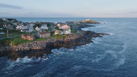 Aerial-Drone-shot-of-York-Beach-Maine-flying-towards-Cape-Neddick-Nubble-Lighthouse-at-Sunset