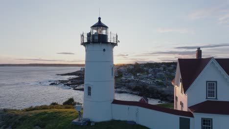 Luftdrohnenaufnahme-Von-York-Beach-Maine,-Der-Bei-Sonnenuntergang-Um-Den-Cape-Neddick-Nubble-Lighthouse-Fliegt