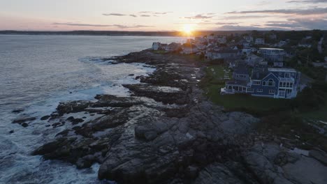 Aerial-Drone-shot-of-York-Beach-Maine-flying-over-Cape-Neddick-Nubble-Lighthouse-into-the-Sunset